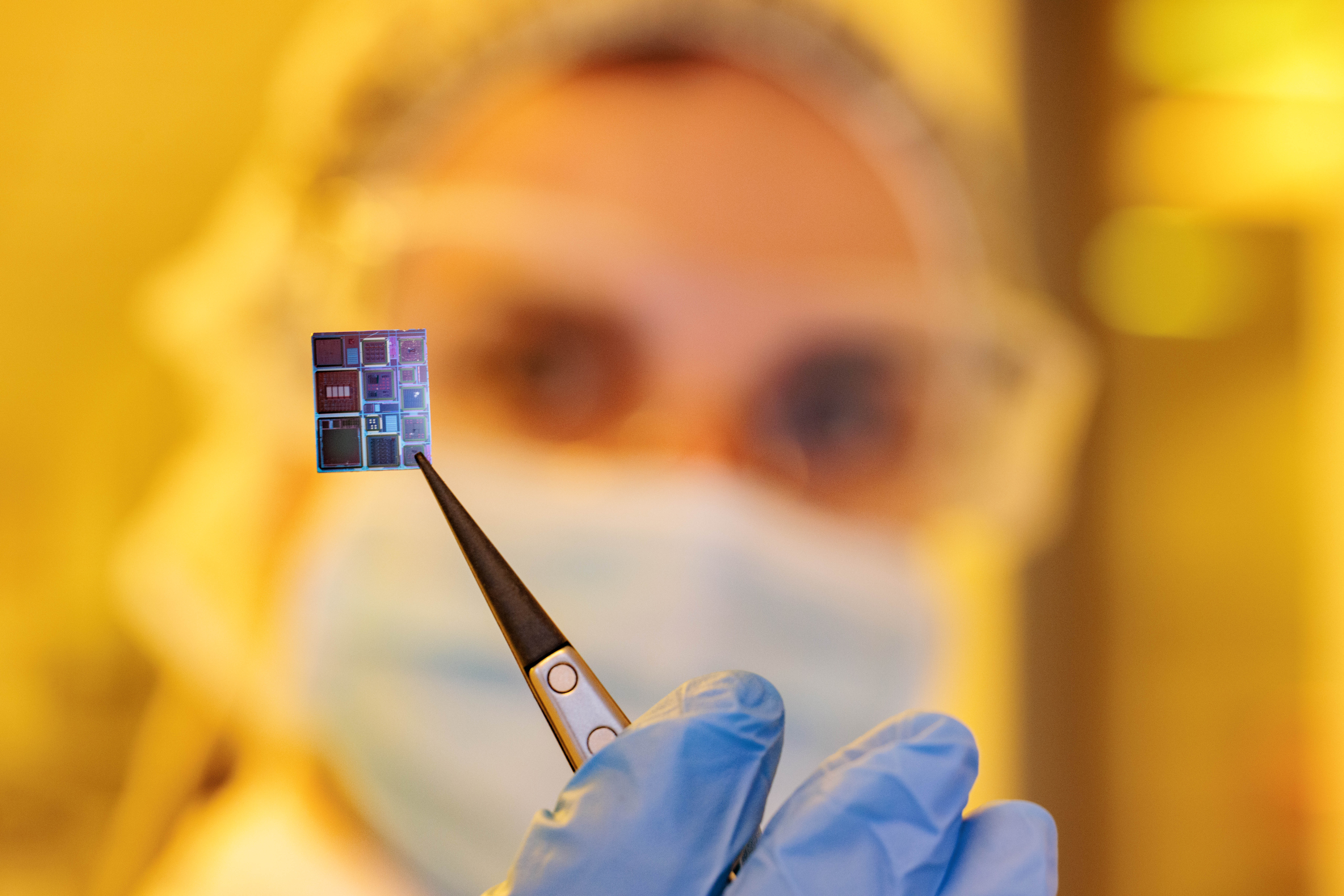Dr. Gina Adam holding one of the entropy oxide memristors she is working on in this study