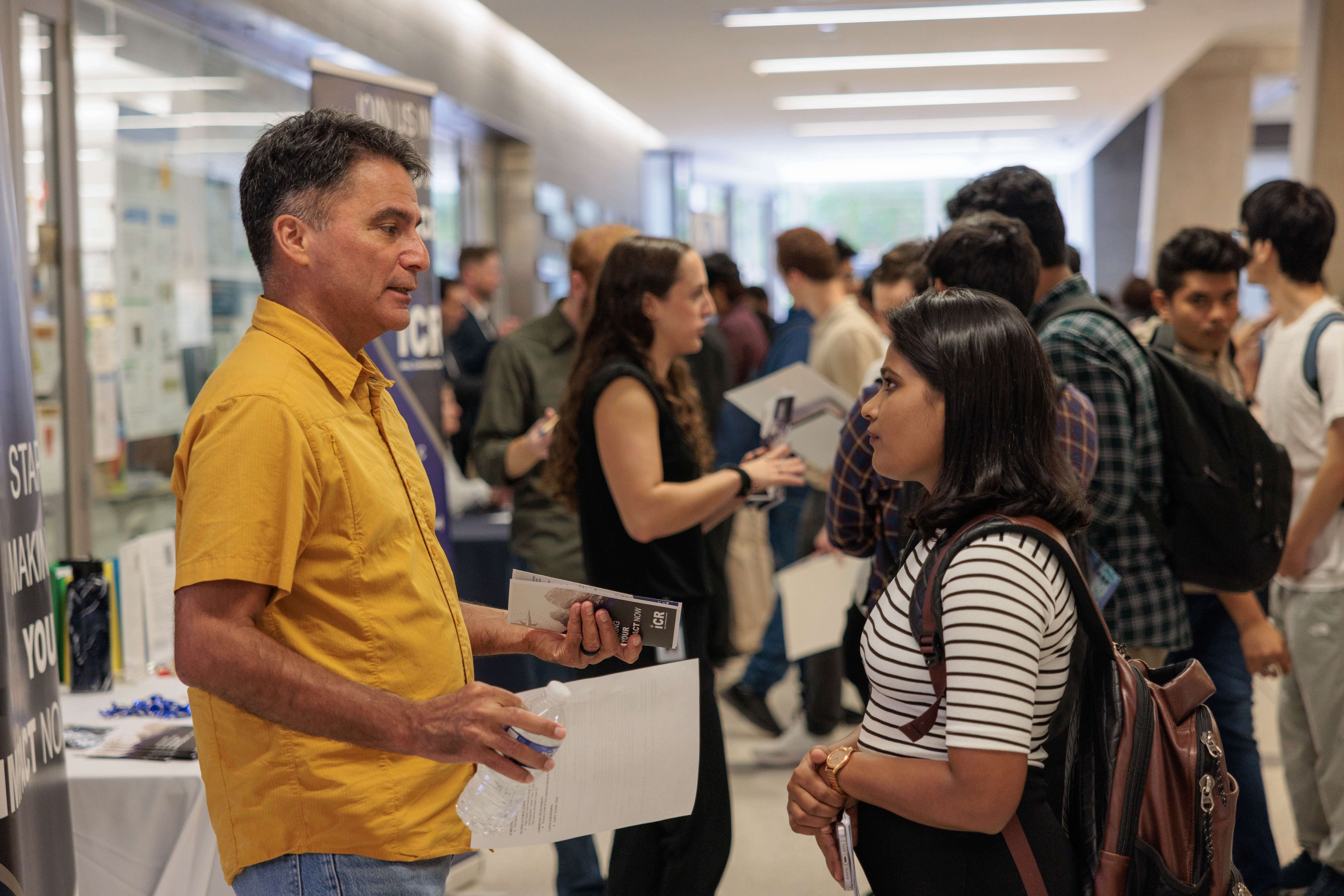 A student conversing with a potential employer in the Science & Engineering Hall