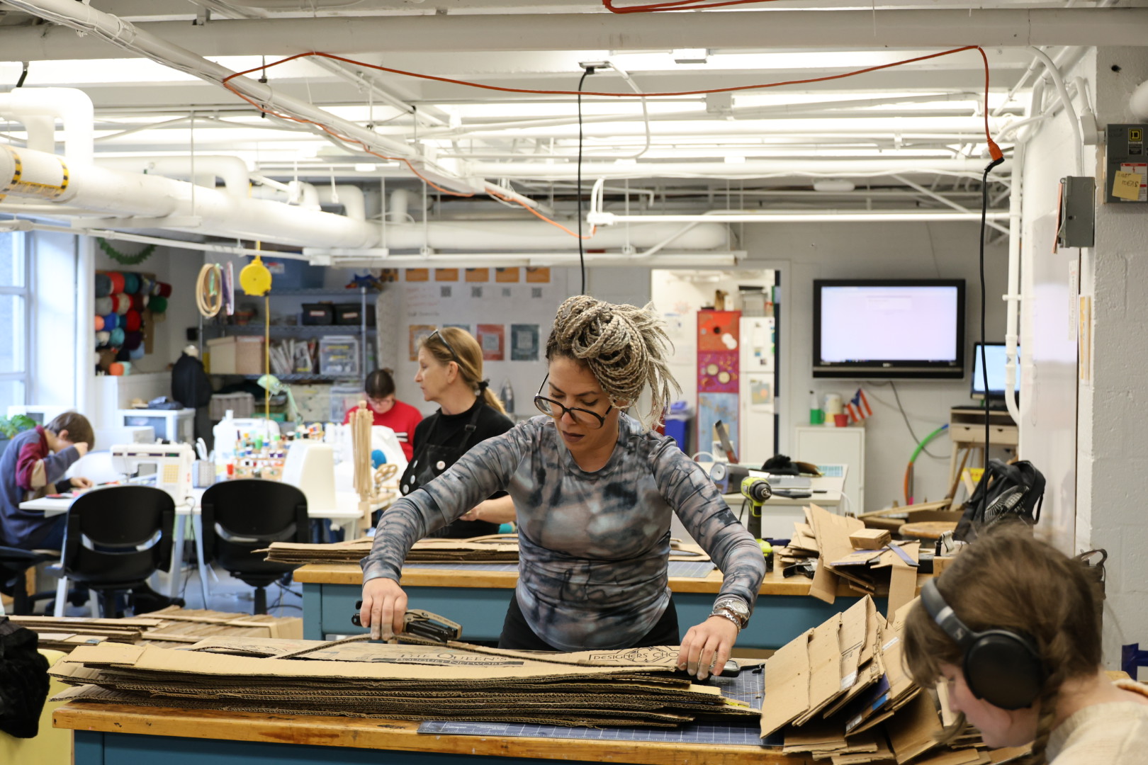 Artist Celia Ledón and students in the GW Innovation Center cutting cardboad