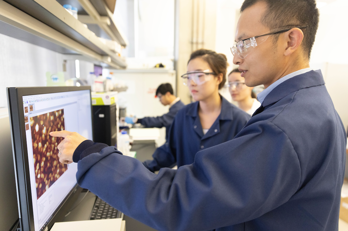 Liu and student examining computer