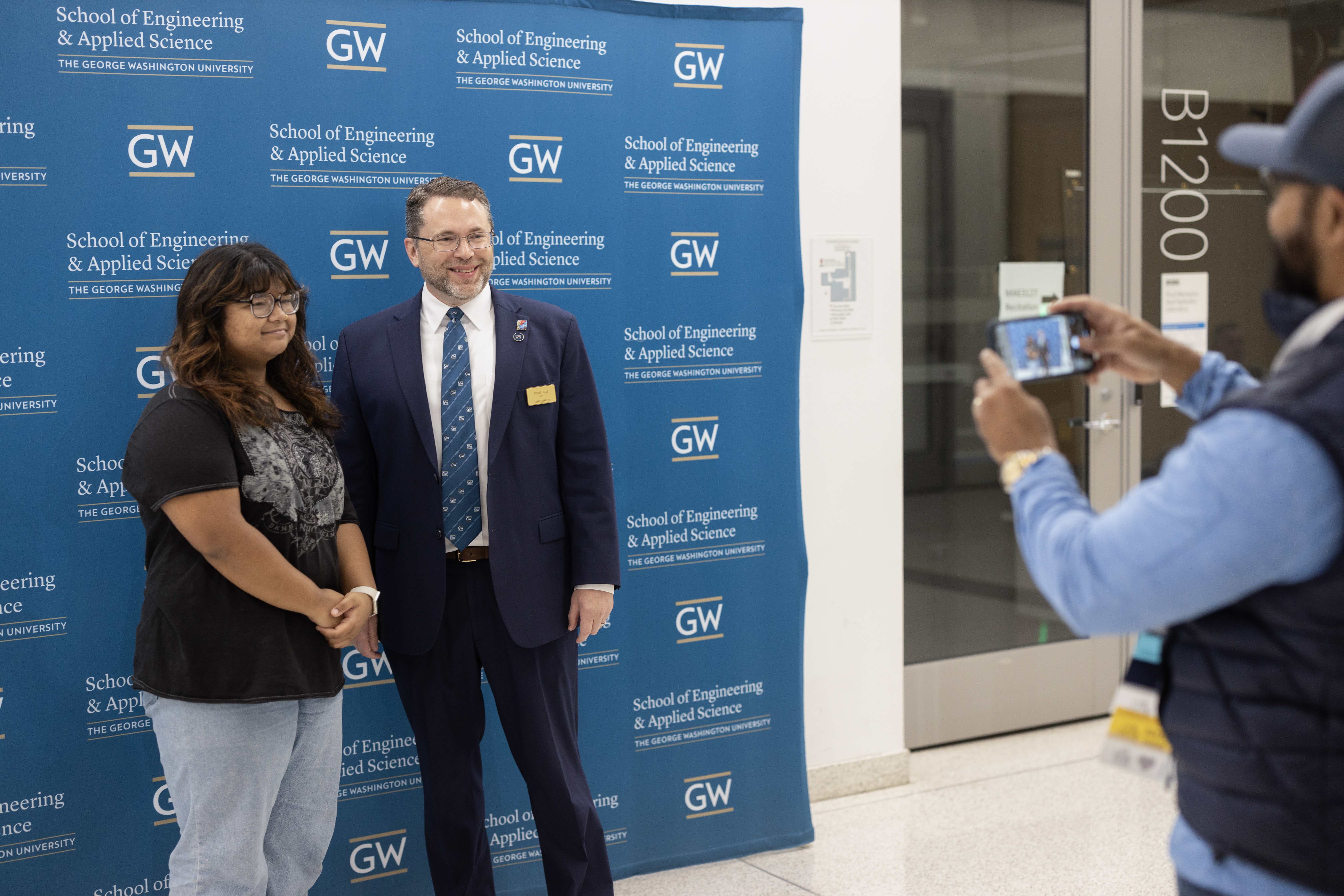 Dean John Lach taking a photo with a student