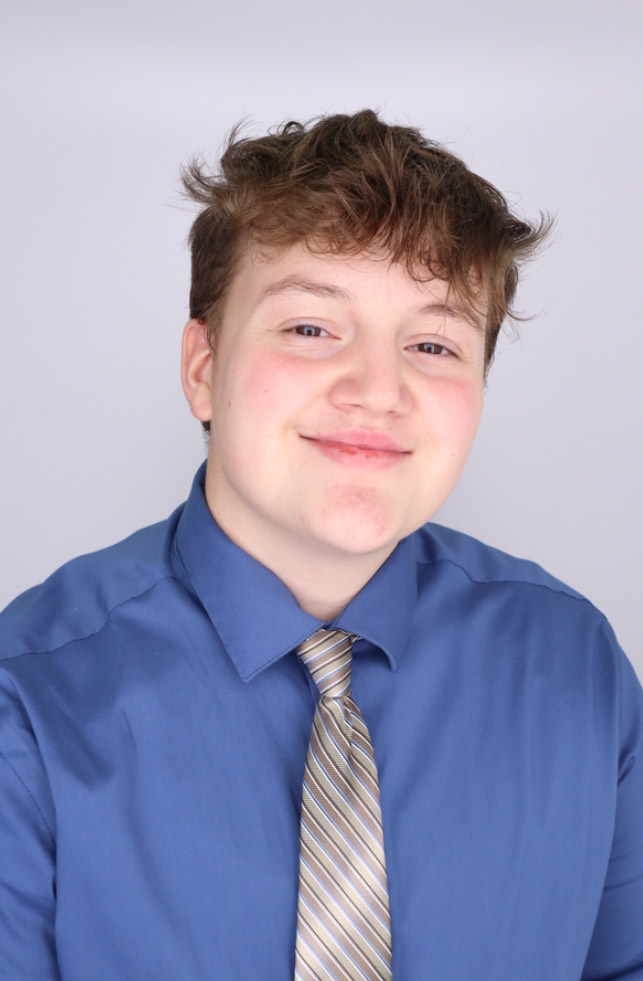 Bo Shively wearing a blue dress shirt with a tie