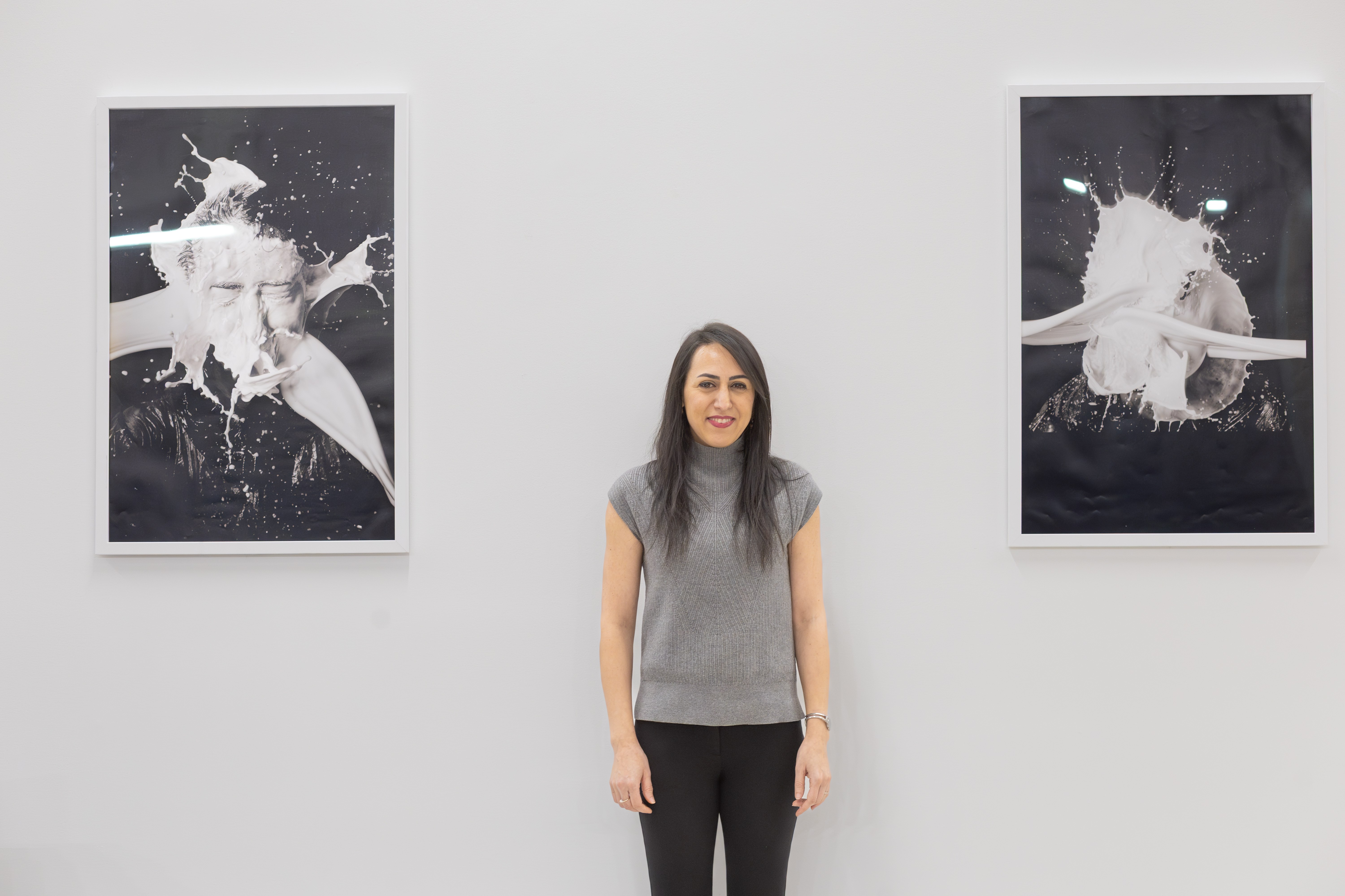 Panah pictured with images from the piece, “The Splash of Milk Streams Impacting a Solid Surface”
