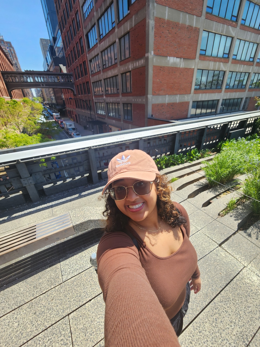 Naomie in a brown shirt and baseball cap