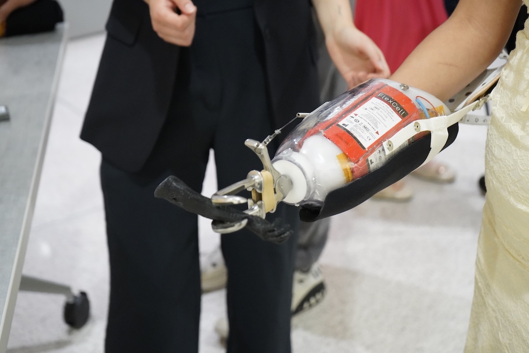 Student showcasing a prosthetic arm