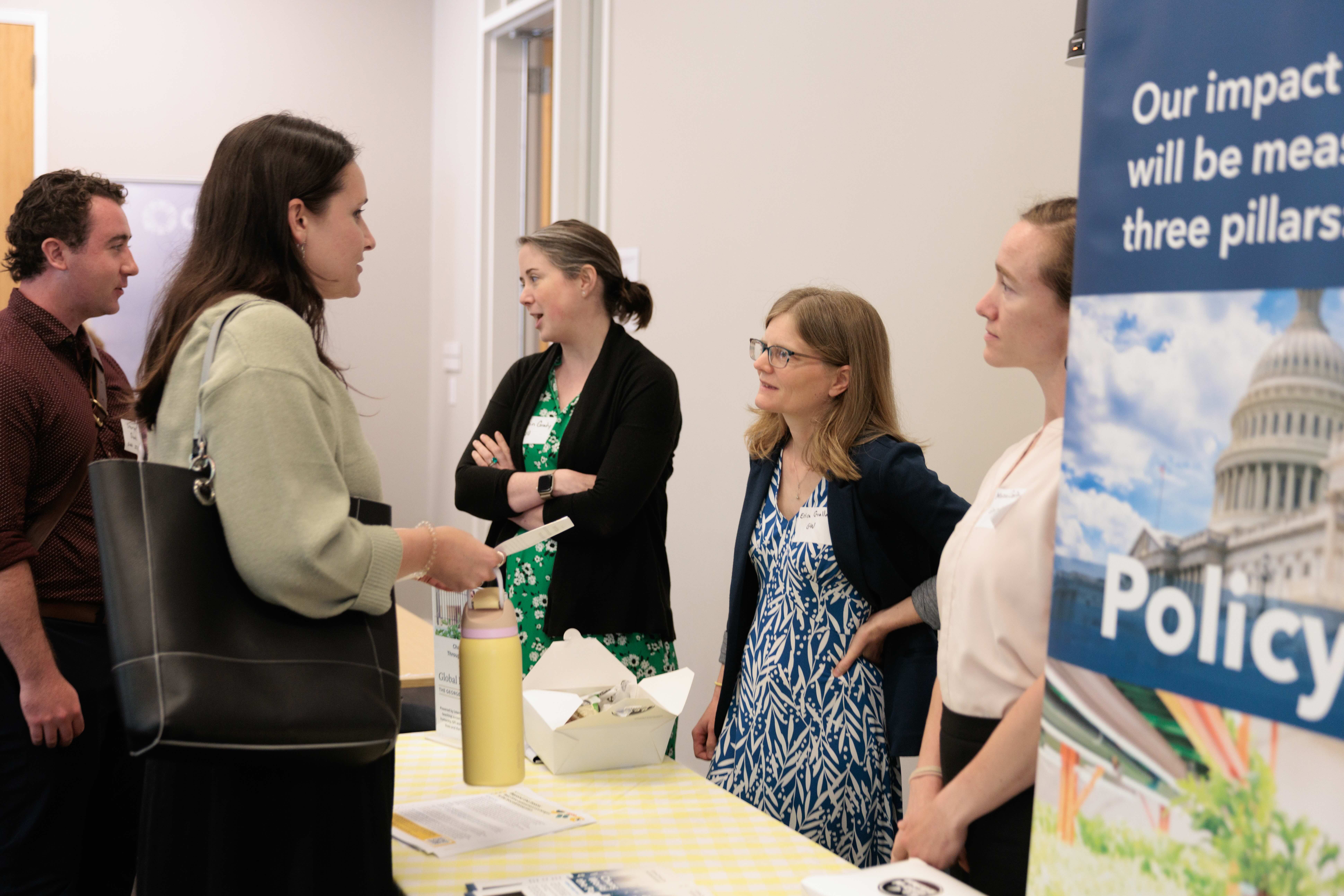 Professors Caitlin Grady and Erica Gralla discussing with attendees.