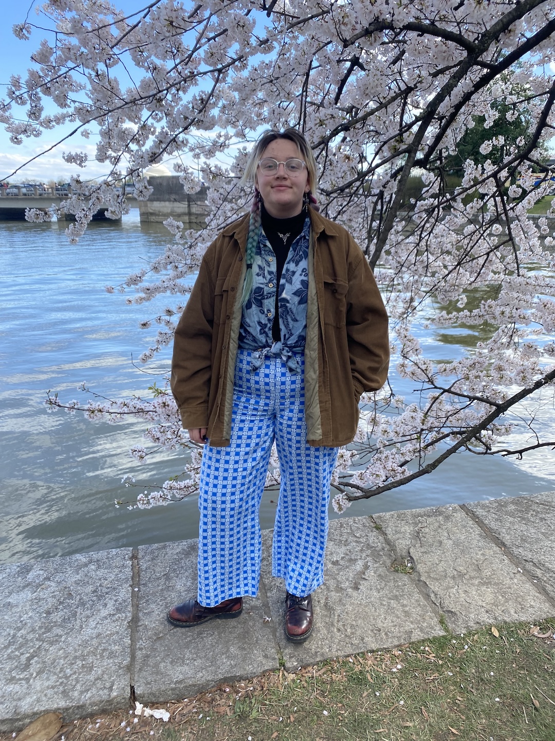 Student standing by a cherry blossom tree