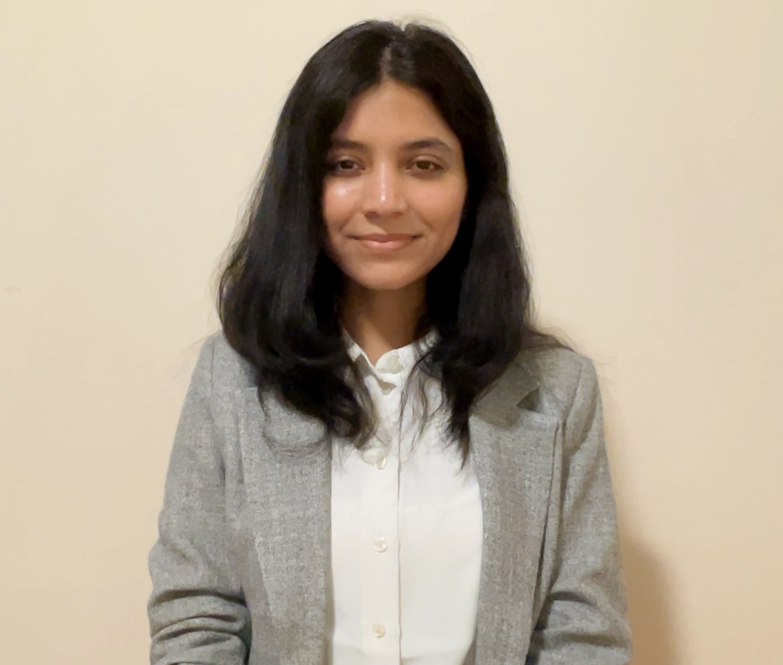 Student in a grey blazer and white collard shirt