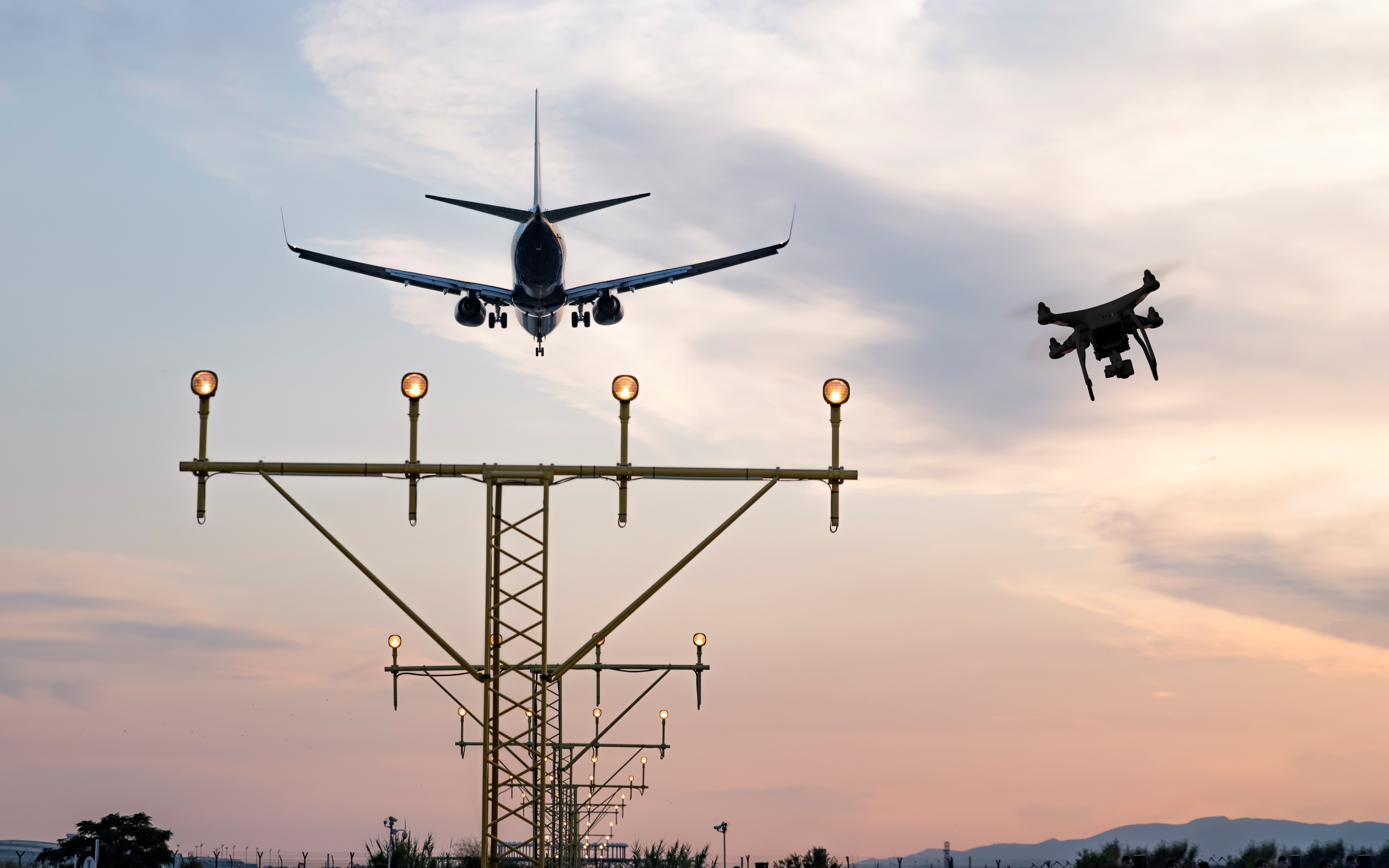 Drone flying at the airport near an aircraft