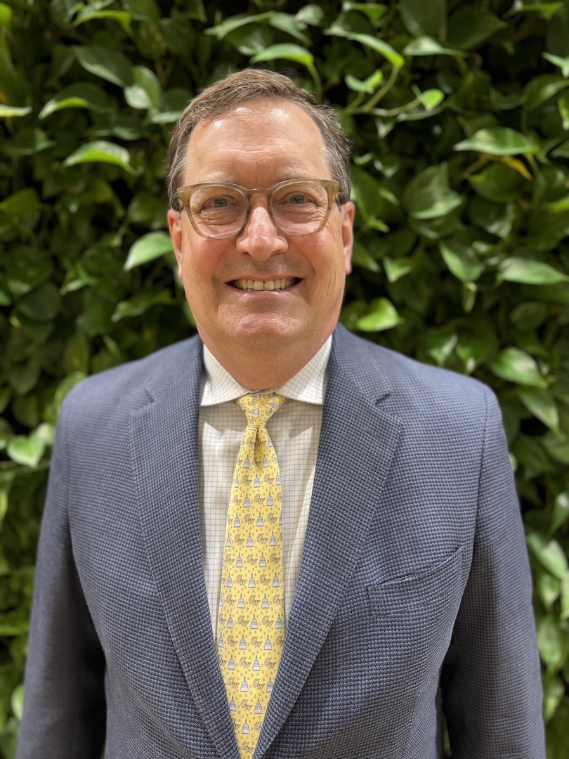 Man in a grey suit with a yellow tie