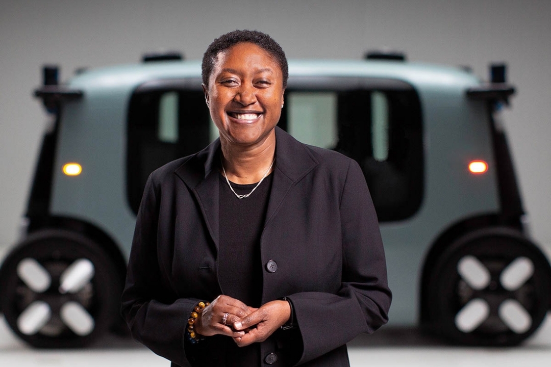 GW Alumni standing in front of an autonomous car