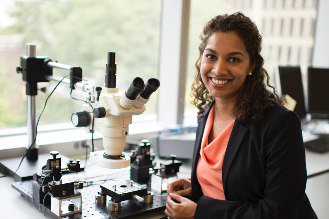Photo of Emilia Entcheva in her electrical engineering laboratory with a microscope
