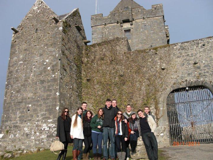 study abroad students posing in front of a castle in Ireland