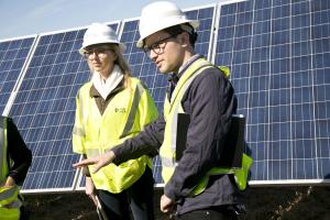 two students in front of solar panels