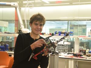 Karl Simon holding a drone in the Science & Engineering Hall's flight test facility