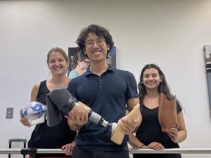 Tripi and fellow students holding the prosthetics they made