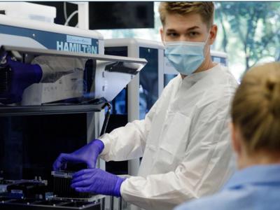 student in lab wearing gloves and mask