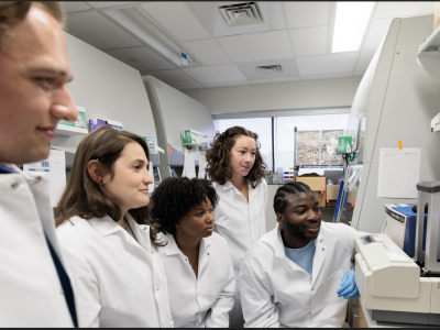 Four researchers looking at equipment within their lab