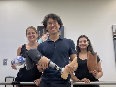 Tripi and fellow students holding the prosthetics they made