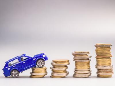 Toy car driving up stacks of coins