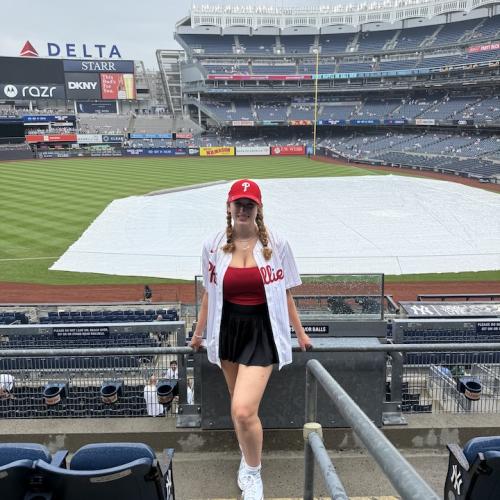 Female standing in the stands of a baseball park