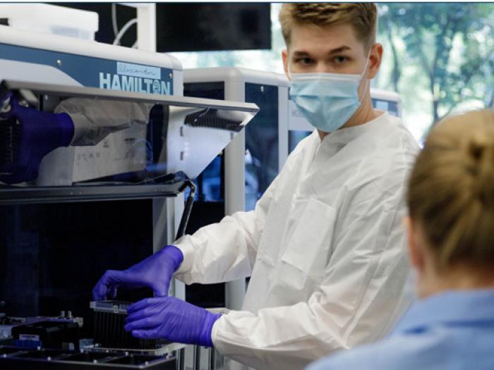 student in lab wearing gloves and mask