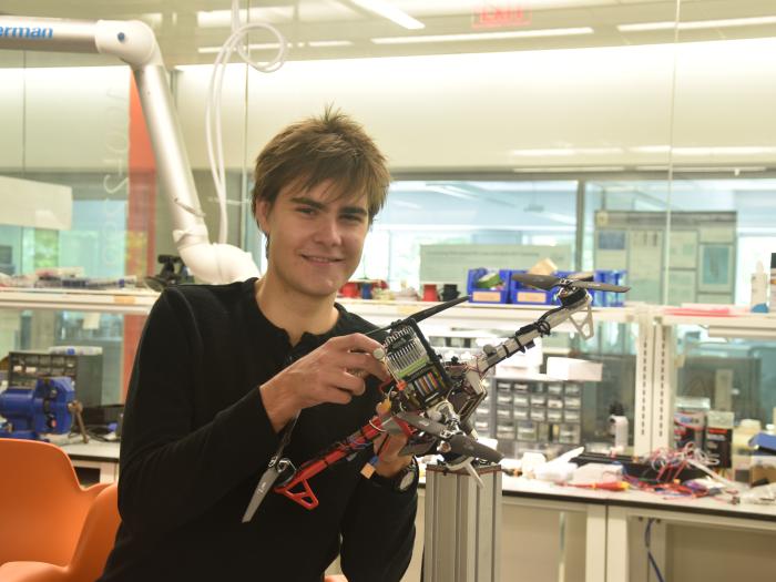 Karl Simon holding a drone in the Science & Engineering Hall's flight test facility