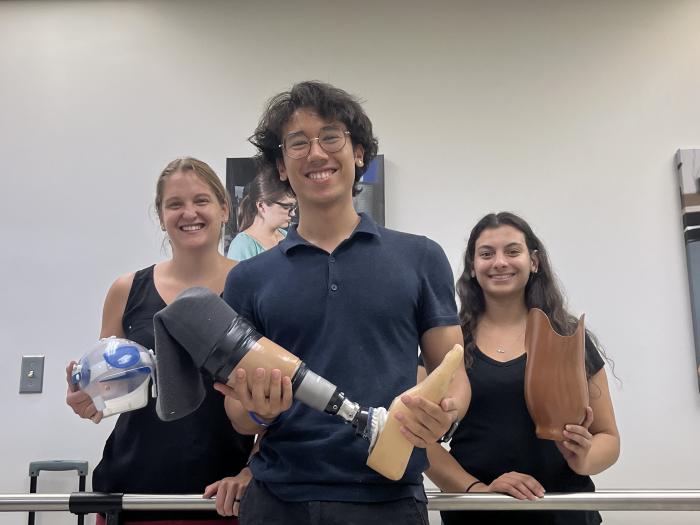 Tripi and fellow students holding the prosthetics they made
