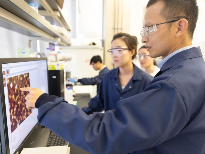 Liu and student examining computer