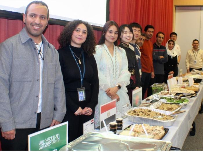 Students standing in front of their country's food dish