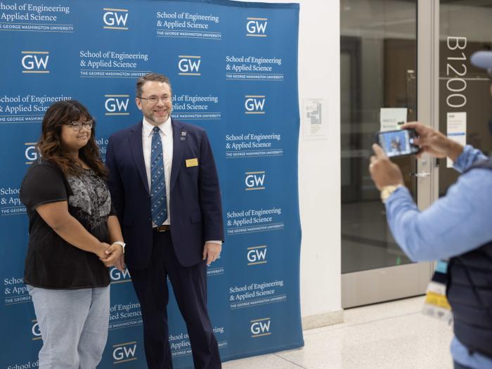Dean John Lach taking a photo with a student