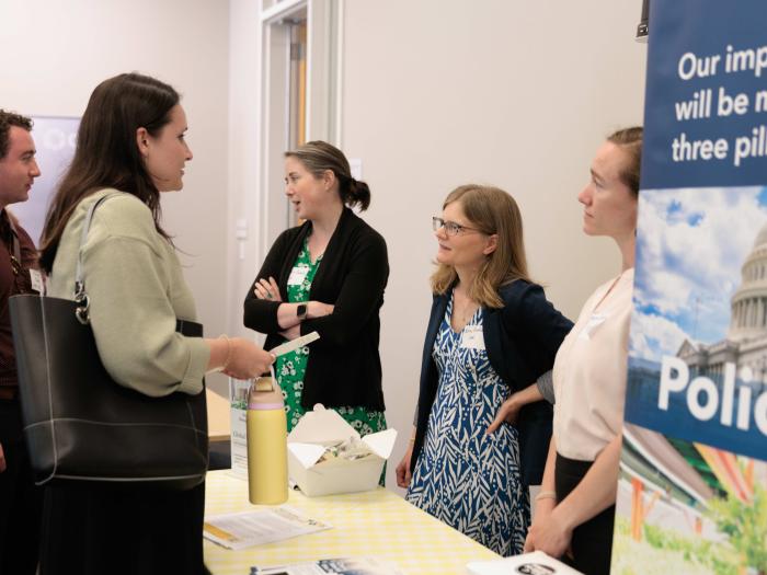 Professors Caitlin Grady and Erica Gralla discussing with attendees.