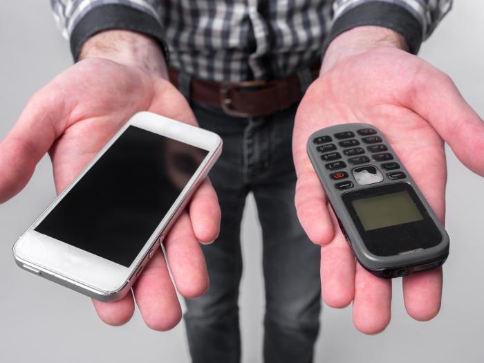 Stock image of person holding a phone in each hand